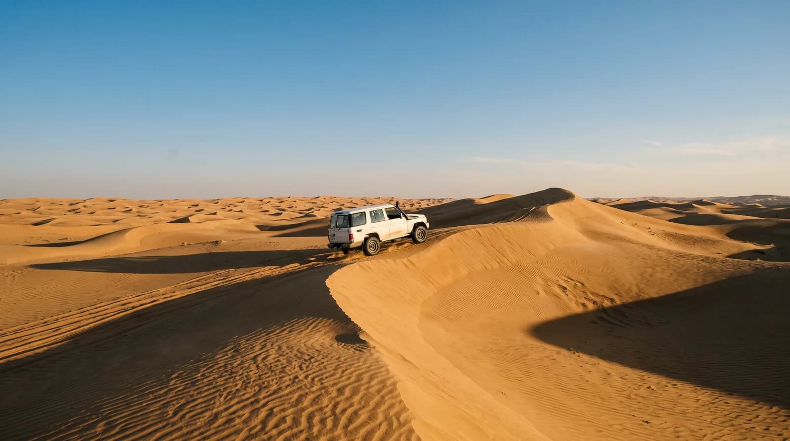 Ein Geländewagen auf Wüstendünen bei Abu Dhabi