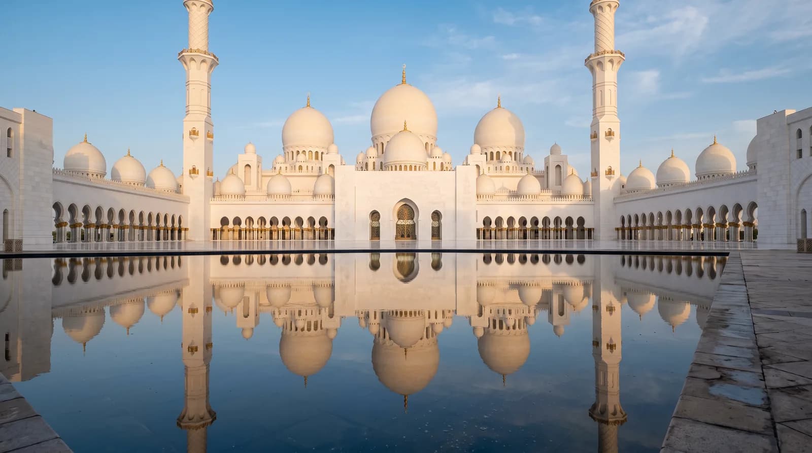 Die weißen Kuppeln der Scheich-Zayid-Moschee bei Sonnenuntergang