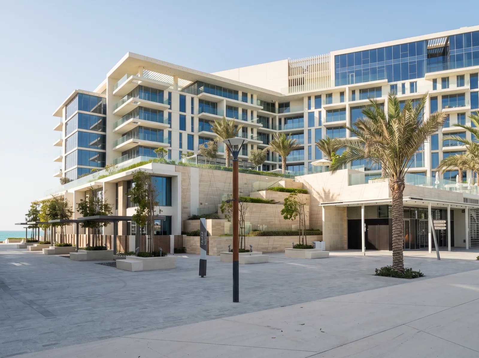 Calçadão e palmeiras diante dos prédios, Mamsha Al Saadiyat
